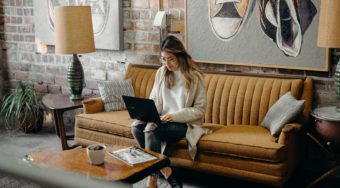 woman working on a laptop sitting on couch in a vacation rental home