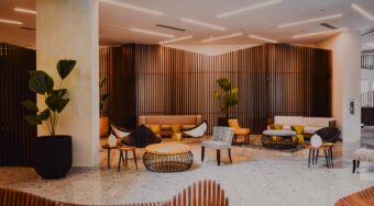 modern furniture in hotel lobby with terrazzo floor and wooden details on walls and benches